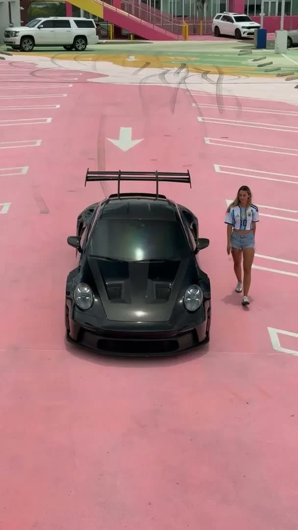 Black Porsche GT3 RS seen from above on a pink rooftop