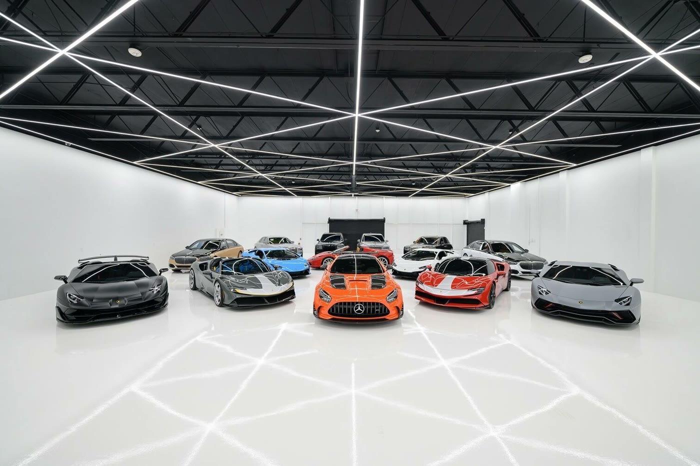 Supercars lined up in a white showroom